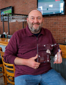 Scott Craddock holding his Workplace Mentor of the Year award.